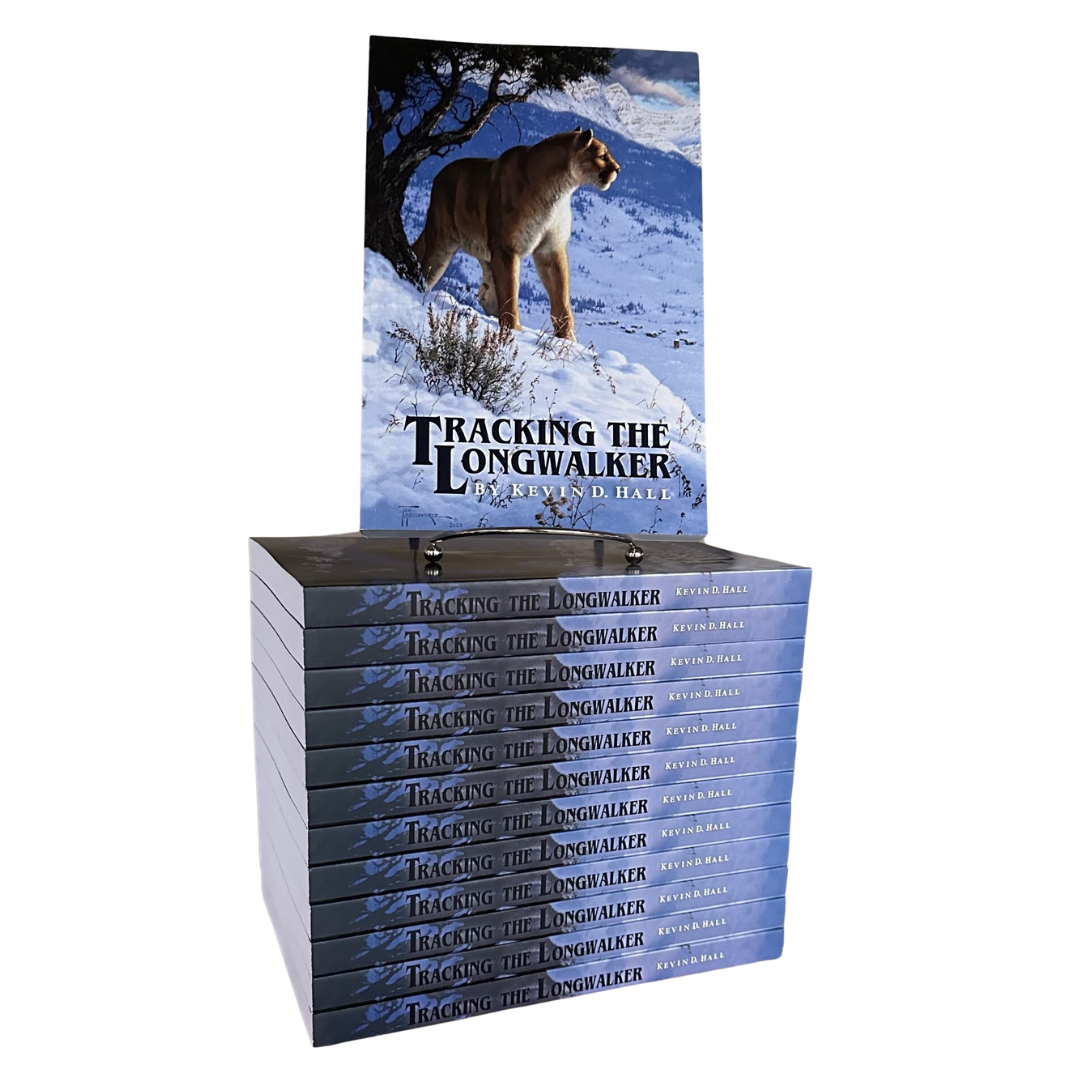 Image shows a stack of the book called Tracking The Longwalker. The book has snow, a tree, a mountain lion